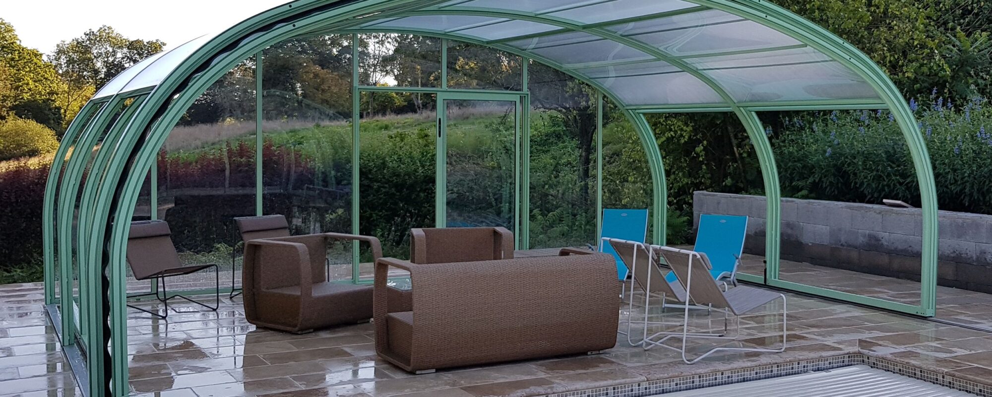 Abri haut de piscine avec salon de jardin