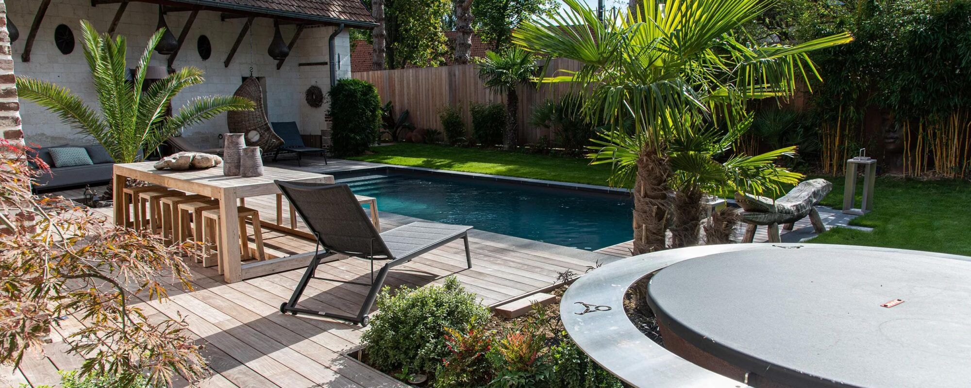 Piscine de luxe avec terrasse en bois dans un jardin calme