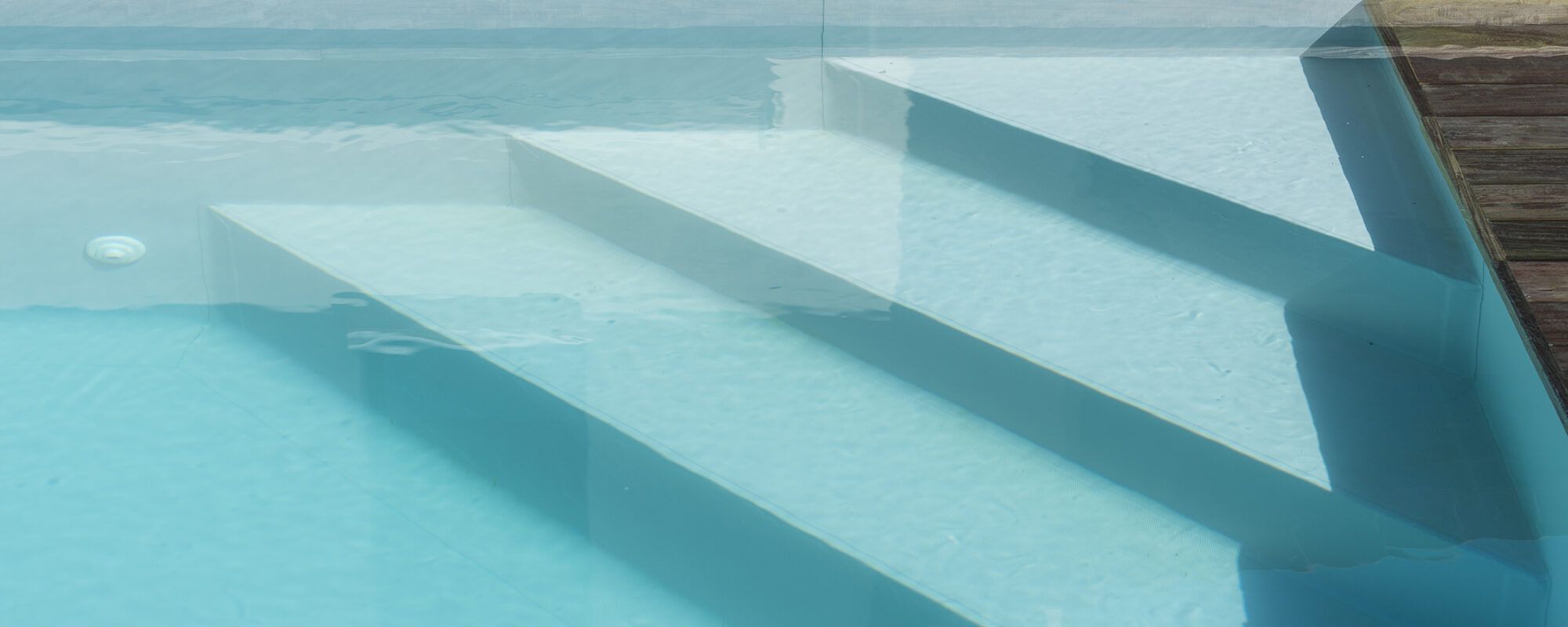 Piscine à débordement sur deux côtés, membrane armée gris clair