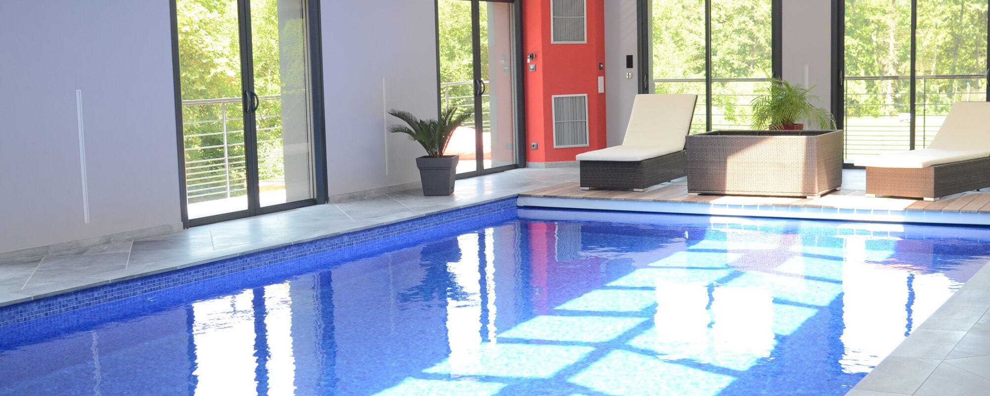 Piscine intérieure rectangulaire avec escalier d'angle et revêtement mosaïque