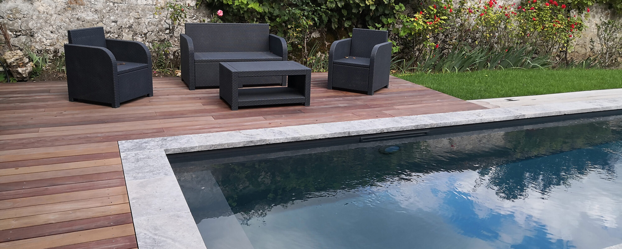 Couloir de nage avec plage en bois et margelles en Travertin