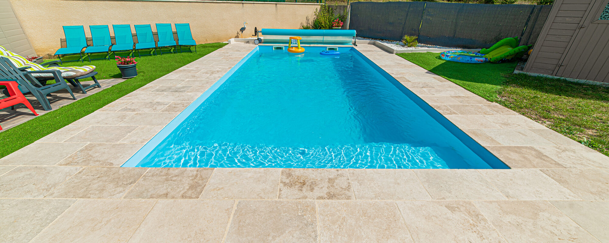 Piscine familiale coque bleu, margelles en pierre naturelle