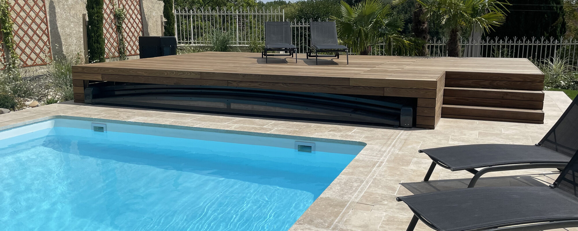 Piscine avec margelles en pierre naturelle et terrasse en bois