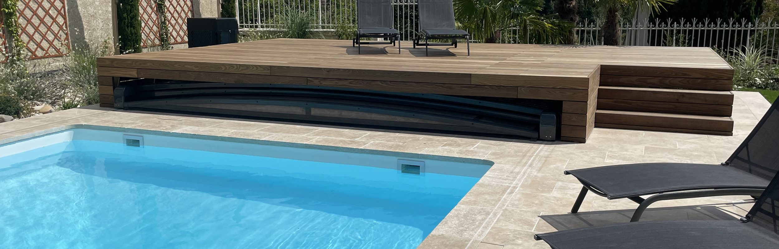 Piscine avec margelles en pierre naturelle et terrasse en bois